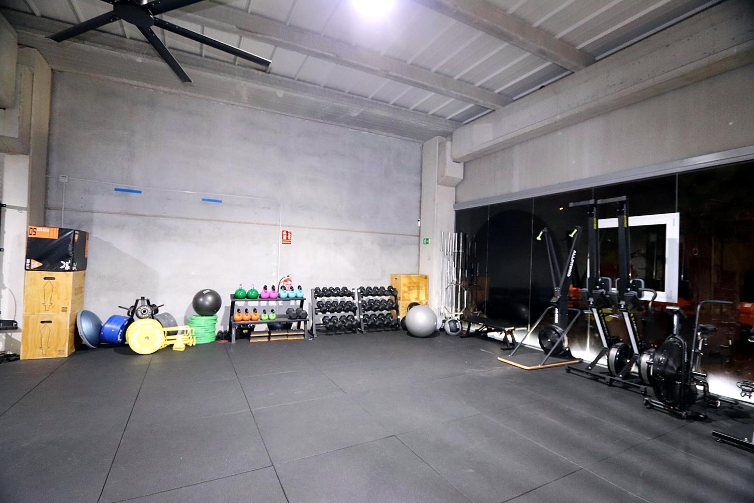 Material de fuerza y cardio: kettlebells, mancuernas, discos, remos y bicicletas